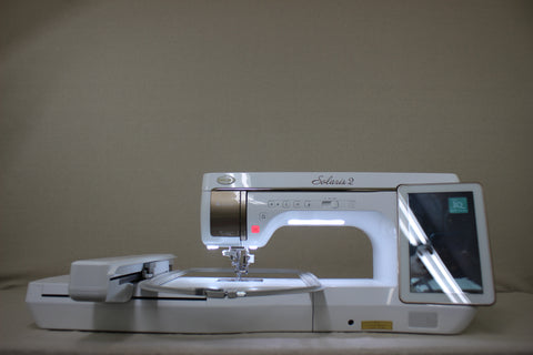A white Baby Lock Solaris 2 sewing and embroidery machine with a digital display.