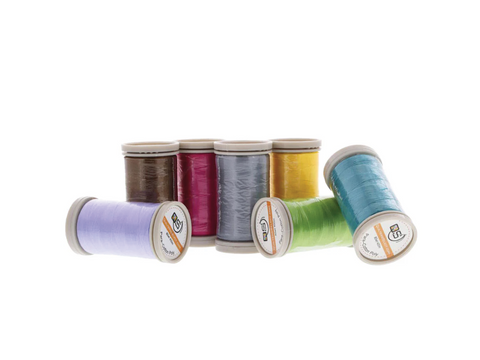 Assorted spools of Quilters Select 80wt Para-Cotton Poly thread in various colors.