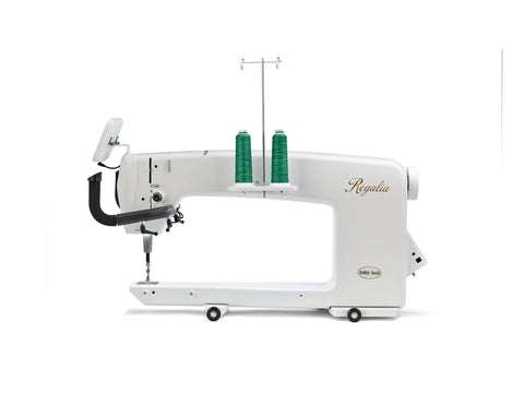 A white Baby Lock Regalia long arm quilting machine with two spools of green thread.
