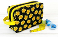 Black tote bag with sunflower pattern, yellow trim, and sewing notions.