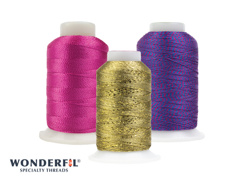 Three spools of WonderFil thread, one pink, one gold, and one blue and pink.