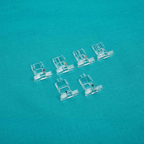 Six clear cording and taping micro insert feet are arranged on a teal surface.